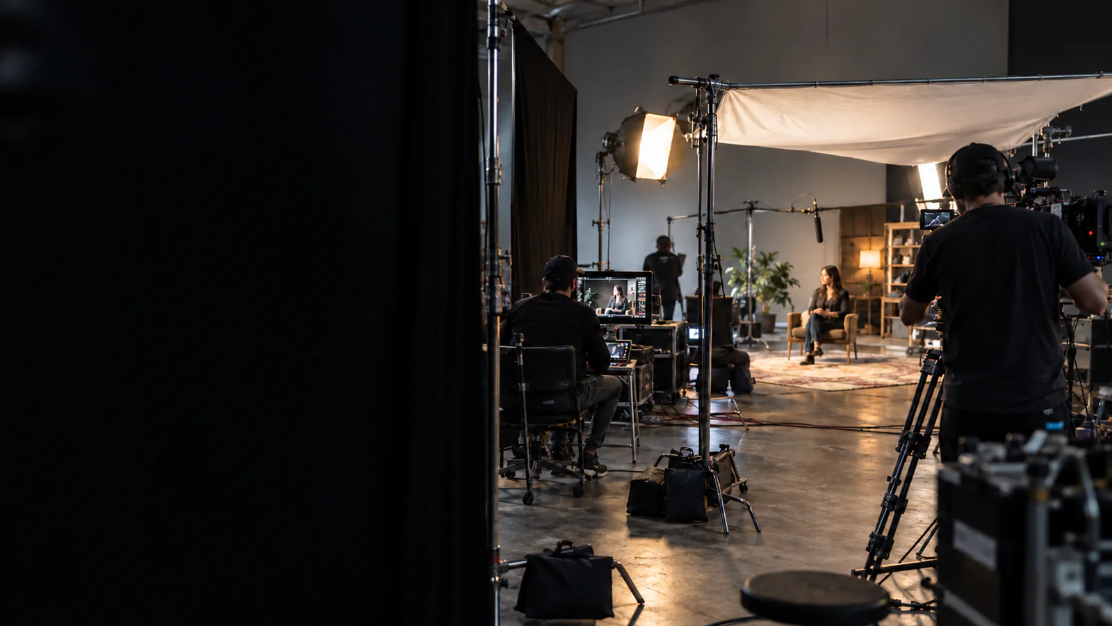 On a True Shot Productions set — a cinematographer films an interview while the director watches the monitor